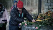 Mitglieder des inklusiven Ensembles des Theaters Reutlingen „Die Tonne“ legen Blumen an der Gedenkstätte Grafeneck nieder.