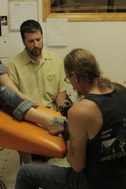 Grand Junction, CO, USA: Dr. Dan Shapiro, a Harvard trained clinical psychologist, quizzes tattoo artist Tom Mangold about the target's distinctive Iron Cross tattoo.