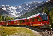 Die Rhätische Bahn bei der Montebello-Kurve nahe der Station Morteratsch am Bernina Pass vor dem berühmten Hintergrund mit dem Morteratsch-Gletscher, dem Piz Palue und dem Piz Bernina.