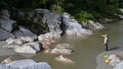 Cody Lundin and Joe Teti standing on rocky river bank.