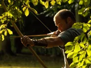 Monty aiming Long Bow in trees.