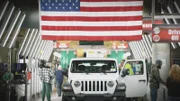 Frontal view of white Jeep with USA flag above. (National Geographic/Sean Carswell)