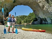Der Fluss Ardèche. Im Vordergrund die Passagierinnen Babsi Geller und Christine Bauer vor dem natürlichen Felsentor Pont d'Arc.