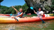 Der Fluss Ardèche. Die Ardèche ist ein Fluss in Frankreich, der in den Regionen Auvergne-Rhône-Alpes und Languedoc-Roussillon-Midi-Pyrénées verläuft. Im Vordergrund die Passagierinnen Babsi Geller und Christine Bauer vor dem natürlichen Felsentor Pont d'Arc.