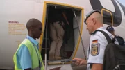 Ein Polizist legt ein Flugticket zur Kontrolle vor.