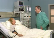 Der ehrlich besorgte Hoteldirektor Hans Altmühl (Henry van Lyck) besucht seine Mitarbeiterin, die Empfangschefin Hella Schneider (Jenny Gröllmann) in der Sachsenklinik.