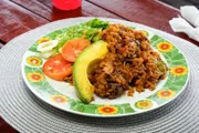 Die trinbagonische Version von Pilaw: „Pelau“, besteht aus Schichten aus braunem Reis, Gemüse, gebräuntem Fleisch und Kokosmilch und ist ein Favorit bei „Tant’s Food Stall“.