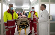 Der Notarzt (Markus Neumann, 2.v.re.) liefert Alexandra Seier (Katrin Ingendoh, liegend) in die Sachsenklinik ein. Begleitet wird der Tross zu Dr. Roland Heilmanns (Thomas Rühmann, re.) Erstaunen von seiner Freundin Katja Brückner (Julia Jäger, 3.v.re.). Rettungssanitäter: Komparsen