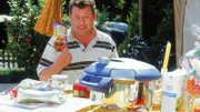 Stolz präsentiert Benno (Willi Thomczyk) sein Geburtstagsgeschenk für Uschi - einen Dampfkochtopf! Seiner Ansicht nach ein praktisches Geschenk, was die Arbeit erleichtert. Und ein Rezeptbuch ist auch noch dabei...