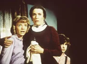 Nellie Oleson (Alison Arngrim, l.) und ihr Bruder Willie (Jonathan Gilbert, r.) flüchten vor ihrem zornigen Vater zu ihrer Mutter (Katherine MacGregor, M.).