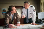 Während der Einsatzleiter des LKA, Lothar Retzky (Steffen C. Jürgens, l.), in den Bauplänen des EKH nach Einsatzmöglichkeiten seiner Scharfschützen sucht, möchte Haller (Hannes Hellmann, r.) erst einmal mit dem Geiselnehmer verhandeln.