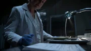 Forensic document examiner looking at signature in lab,