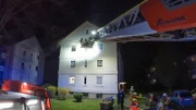 In Lünen eilt ein Löschfahrzeug der Berufsfeuerwehr zu einem Wohnungsbrand, um einer Frau zu helfen, die am Fenster steht.