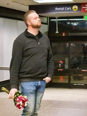 Mike waits for Natalie at the airport.