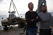 L-R: Eric Schmitt and Darrell Miklos in posing in front of submarine.