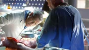 Dr. Raymond Langston und Dr. Robbins untersuchen den Körper des Opfers.