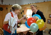 Martin (David Paryla, r.) berichtet Hildegard (Antje Hagen, l.) stolz davon, der Patenonkel von Kiras und Xavers Sohn zu sein.