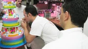 Danny and Buddy watch Remy as he writes Happy Birthday on Marco's cake.