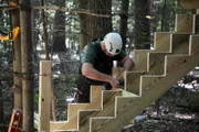 A worker works on the staircase of the cabin