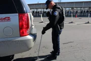 CBP Thomas benutzt einen Unterbodenspiegel, um die Unterseite des Fahrzeugs eines Passagiers zu untersuchen, der versucht, die Grenze in El Paso, Texas, zu passieren. (National Geographic für Disney)