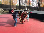 Das Passagierpaar Ina (hinten links) und Rodrigo (vorne links) besucht von Quebec aus ein kanadisches Indianerreservat und bekommt Tänze und Rituale gezeigt.