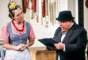 Gerdi (Gerda Steiner) versucht herauszufinden, was der „Schnüffler“ (Pit Krüger) für das Gewerbeaufsichtsamt notiert.