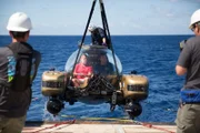 Wide shot of Jim Sinclair submerging in the submarine.