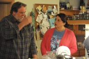 Stadlbauer (Andreas Geiss) diskutiert mit Monika (Christine Reimer) über einen Zeitungsartikel, der den Niedergang von Weltraumschrott prophezeit.