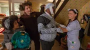 Unter den belustigten Blicken von Tom (Ellis-James Naylor) und Simon (James Merry), zeigt Tess (Andrea Valls) Herrn Noack (Darsteller unbekannt), wie man Verbände anlegt.