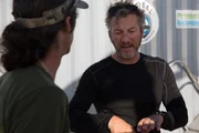 Darrell Miklos and Mike Perna having a conversation near the submarine.