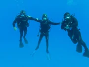 Darrell Miklos, Jim Sinclair, and Eric Schmitt celebrating in the water after gold coin discovery.