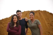 CHARING, KENT, U.K.- (Left to right): Volunteers Lindsay Ip, Will Watremez and Sian Proctor stand in front of mounds of sand representing galaxies in the universe.