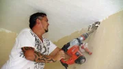 Dominik geht mit schwerem Gerät gegen die Wand vor.
