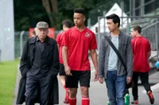 Edwin Bremer (Tilo Prückner, l.) und Hui Ko (Aaron Le, r.) befragen den FC-Köln-Fußballer Timo (Emmanuel Kämpfer) nach seinen verletzten Kollegen.