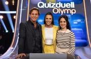 Moderatorin Esther Sedlaczek (M.) mit den Kandidat:innen des Teams "Der Alte": Schauspieler Thomas Heinze (l.) und Schauspielerin Stephanie Stumph (r.).