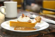 Der klassische Süßkartoffelkuchen, ein traditionelles Dessert aus dem Süden, hergestellt aus cremigen, gewürzten Süßkartoffeln aus der Region, garniert mit Schlagsahne, Streuseln und Süßkartoffelchips – serviert im Restaurant „Buxton Hall“ in Asheville.