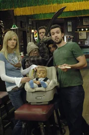 Als Dee (Kaitlin Olson, l.) und Mac (Rob McElhenney, r.) ein Baby in einem Müllcontainer finden, nehmen sie es kurzerhand mit nach Hause, um es großzuziehen.