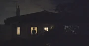 Silhouette eines vor einem Haus stehenden Mannes