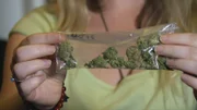 BOSTON, MASS.- Lila, a marijuana user, holding a small bag of Marijuana.