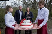Oskar Schütz (Marek Erhardt, 2.v.l.) und Lena Testorp (Anna von Haebler, 2.v.r.) lassen ihr Hochzeitsgeschenk in Form der Hochzeitstorte von der Cateringfirma zu den Feiernden bringen.