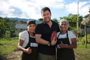 James Wong posiert für das Foto mit Schokoladenherstellerinnen in Peru