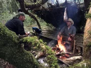 Jeff Zaush und EJ Snyder unterhalten sich am Lagerfeuer in der Unterkunft.