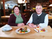 Brauerei-Gasthof Schönram in Schönram: Die Wirtsleute Arno und Andrea Henninger stellen das Menü des Tages vor. Vorspeise: Maultaschensuppe - Hauptgericht: geschmorte Schweinebäckchen mit Brezn-Quark-Knödel in Dunkelbiersauce - Nachtisch: Weißbier-Eis-Soufflé.