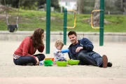 Brennan (Emily Deschanel, l.) und Booth (David Boreanaz) genießen ihr Glück mit Töchterchen Christine (Ali Louise oder Susanna Allan Hartman), doch das Familienidyll ist jemandem ein Dorn im Auge...