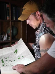 Mark and Jay looking at a map they found amongst the items in the homestead.