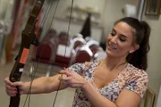 Traci carefully examines a bow and arrow set she found during the auction preview in St. Paul, as seen on Travel Channel's Baggage Battles.