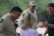 Fish and Game Warden Coley Leonard and Eric Cooper looking at evidence of an injured deer.