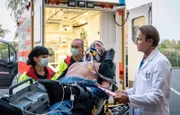 Udo von Wackerstein (Dirk Schoedon, liegend) wird von der Notärztin (Sarah Arntz, li.) in die Sachsenklinik eingeliefert. Dr. Martin Stein (Bernhard Bettermann, re.) staunt nicht schlecht, als er erzählt bekommt, dass von Wackerstein nun Schornsteinfeger ist.