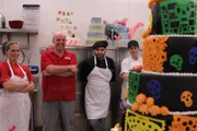 The crew looks on at the finished Day of the Dead cake.