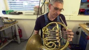 Blasinstrumentenbauer Eckard Graf prüft das von ihm gebaute Horn